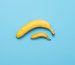 baby banana compare size with banana on blue background. size penis concept